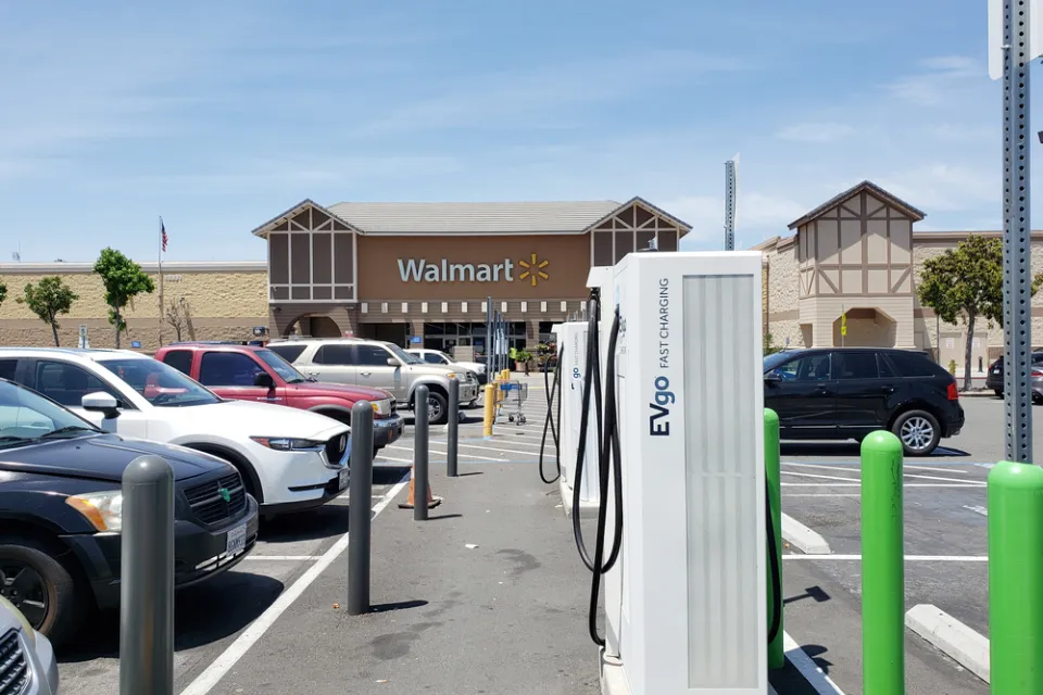 Electirc vehicle charing stations are visible in the parking lot of a Walmart store.